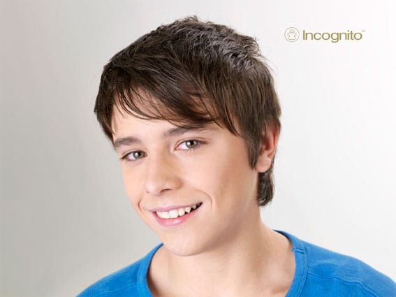 Teen boy smiling with no visible braces while wearing Incognito lingual braces